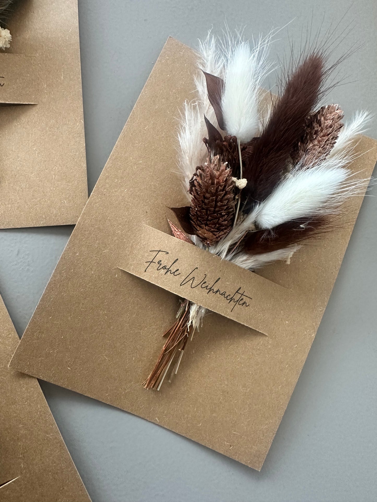 Natürliche Weihnachtskarte mit Trockenblumen in Kupfer, Braun und Weiß – stilvoll und warm