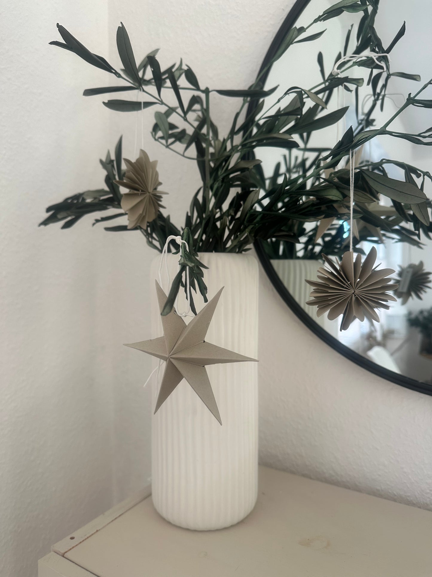 Mehrere naturfarbene Papiersterne als hängende Weihnachtsdekoration