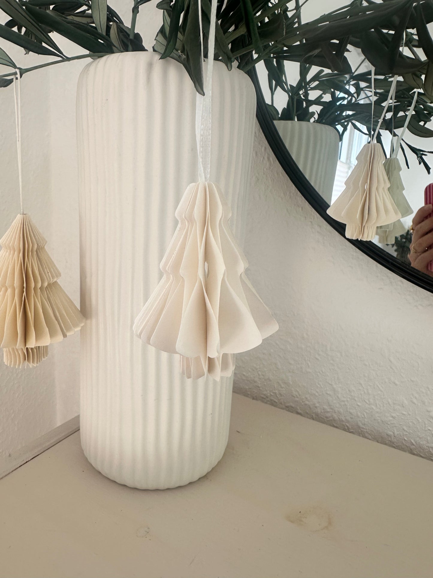 Papier-Weihnachtsbaum hängend an Olivenzweigen
