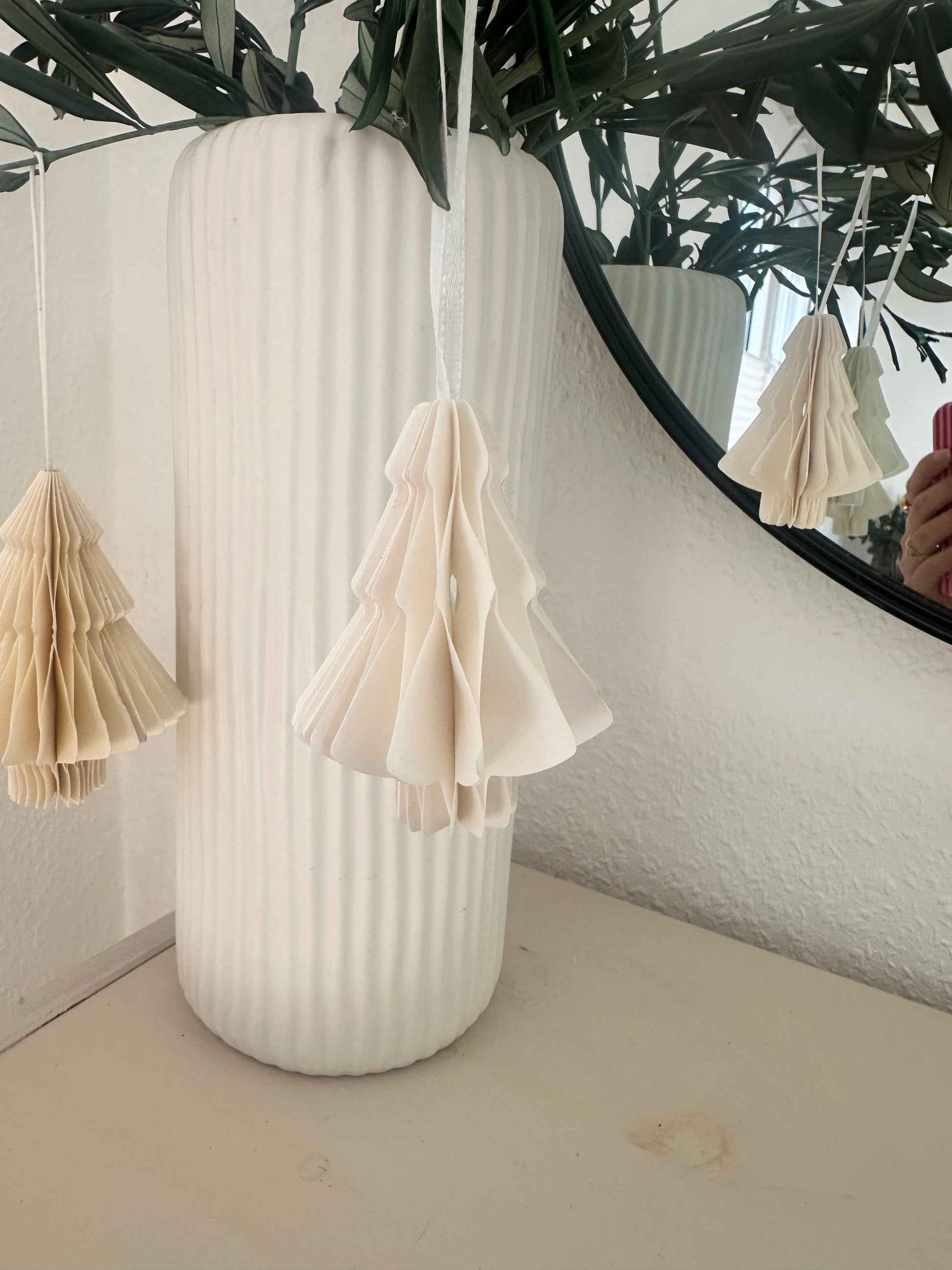 Papier-Weihnachtsbaum hängend an Olivenzweigen