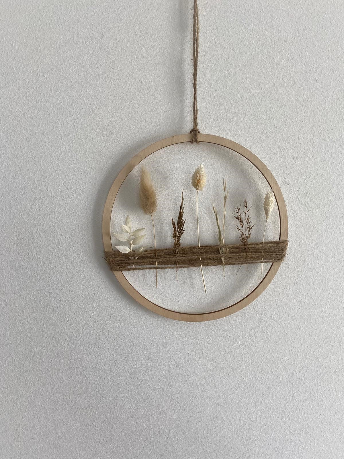 Holzring mit Gräsern und beigen und weißen Trockenblumen -