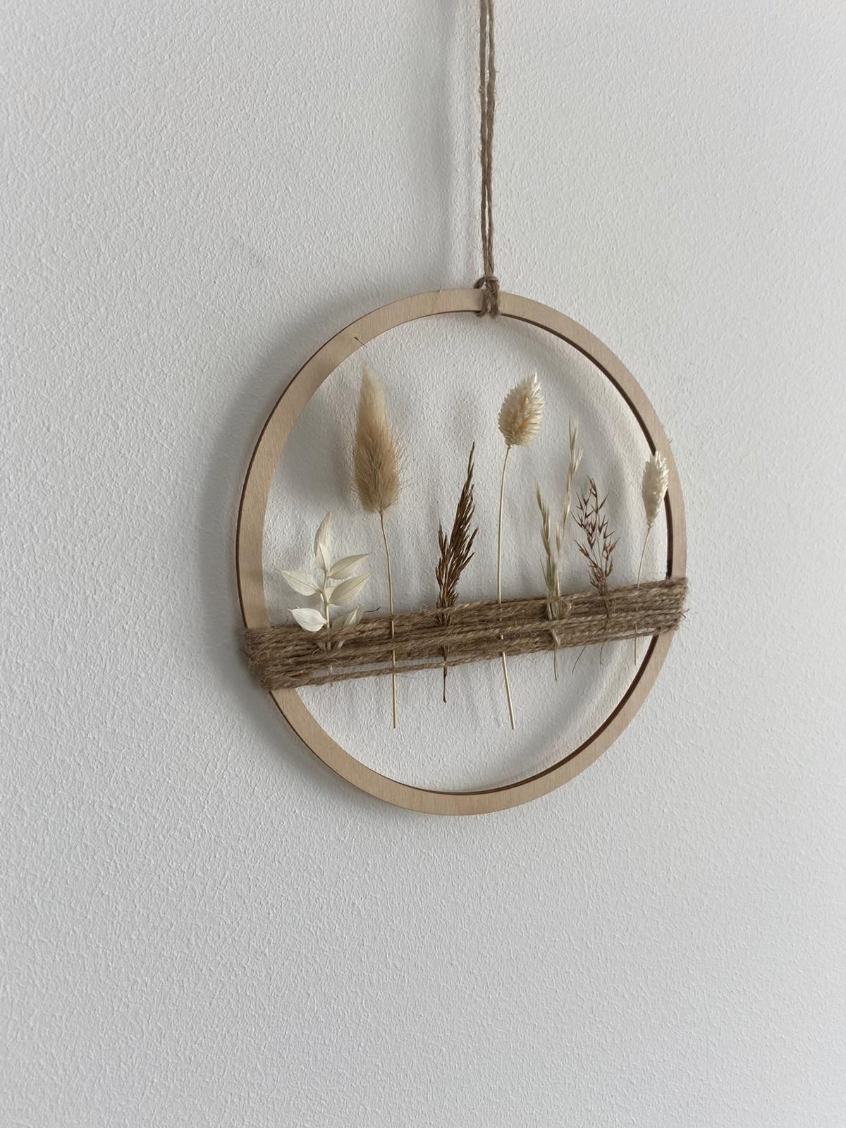 Holzring mit Gräsern und beigen und weißen Trockenblumen -