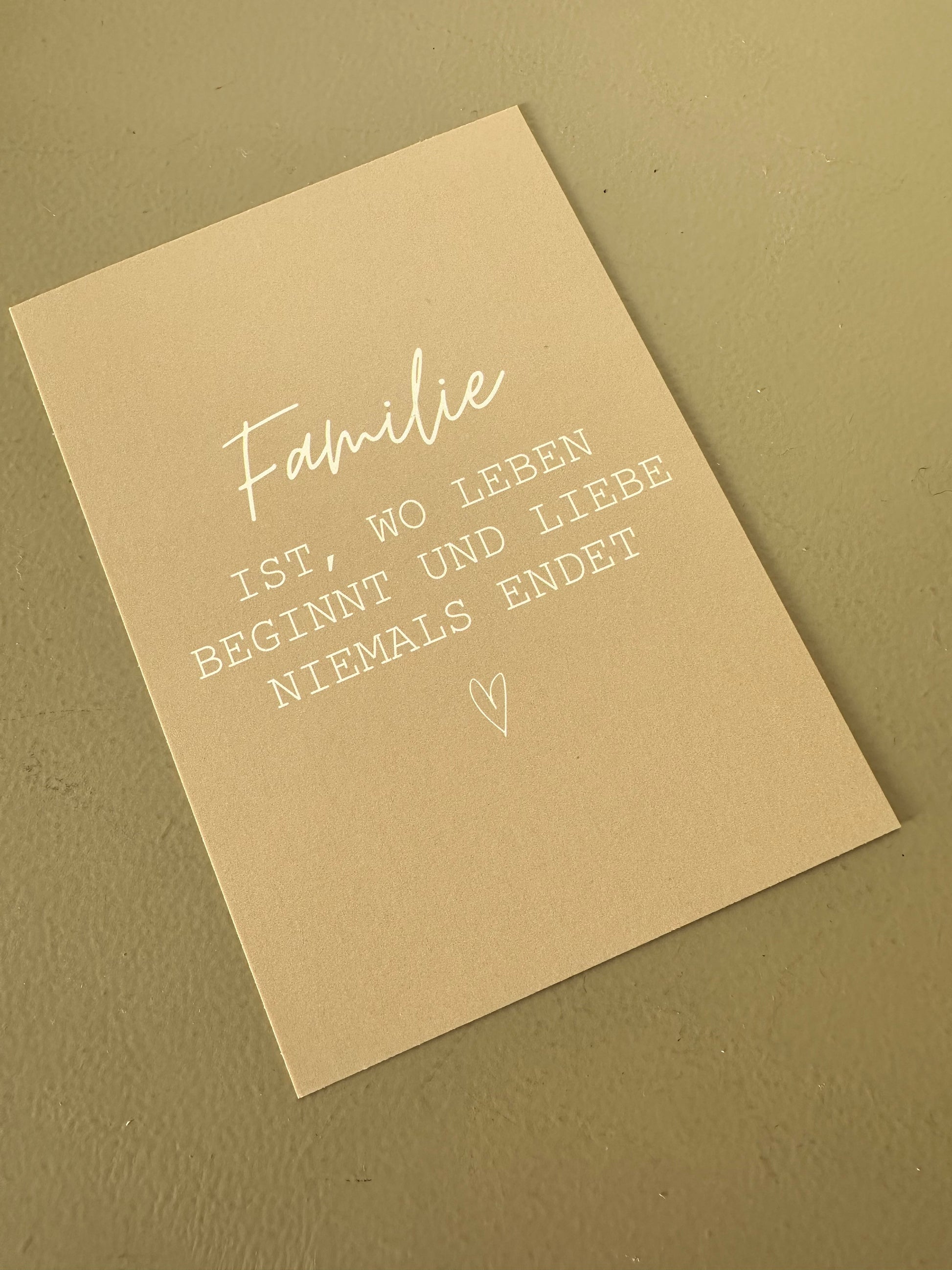 Beige Postkarte mit weißem Spruch über Familie in einem Bilderrahmen – minimalistische, liebevolle Dekoidee.