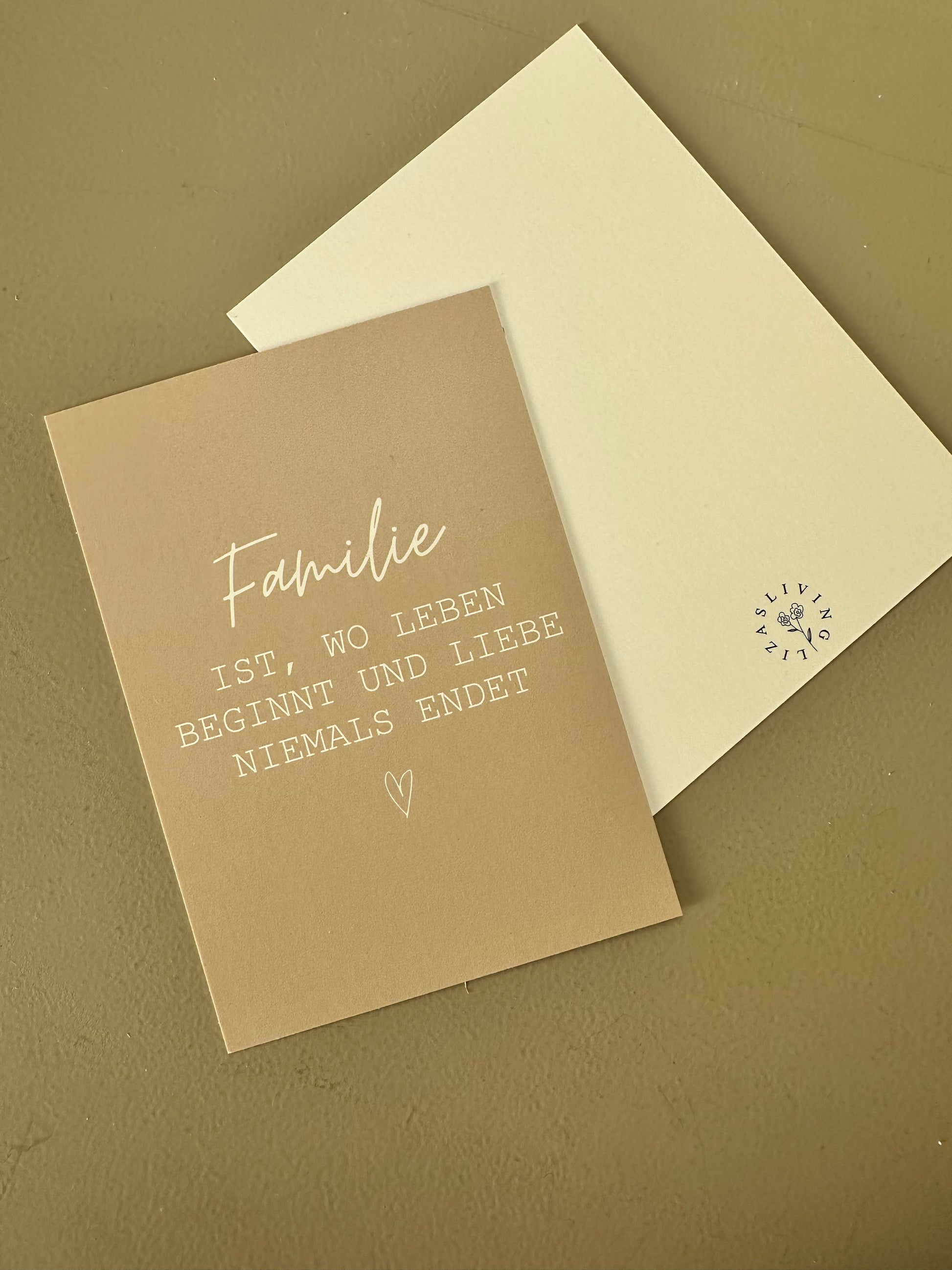 Postkarte in Beige mit weißem Spruch „Familie ist, wo Leben beginnt und Liebe niemals endet“,