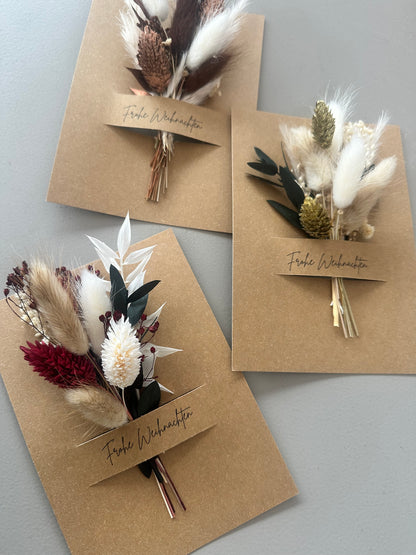 Nahaufnahme eines Trockenblumenstraußes auf Weihnachtskarte – feine Handarbeit mit natürlichen Materialien