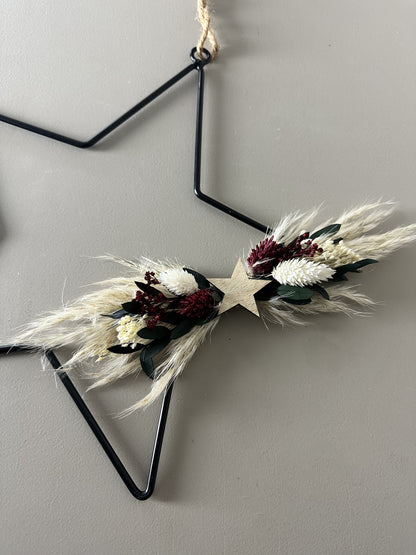 black metal star with dried flowers