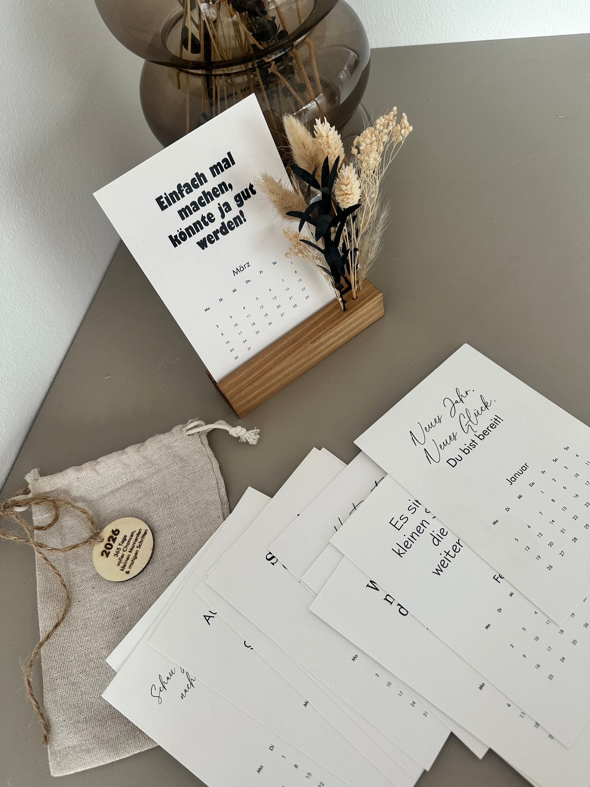 Tischkalender 2026 mit Holzaufsteller und Trockenblumen, dekorativ auf Schreibtisch, perfekte Geschenkidee