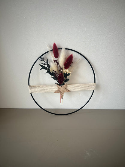 Dekoring mit weihnachtlichem rotem Strauß, Holzstern und Baumwollgarn